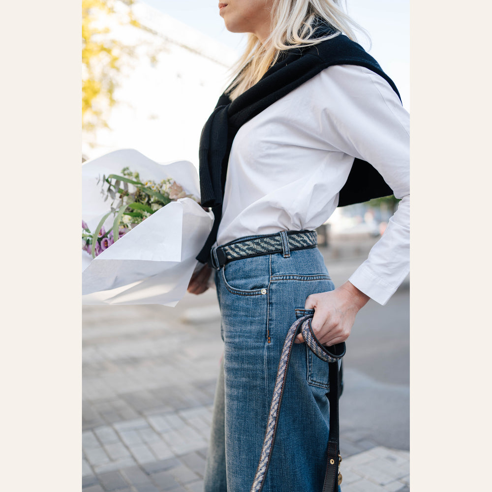 Ceinture Zenya portée avec un jean, un bouquet à la main